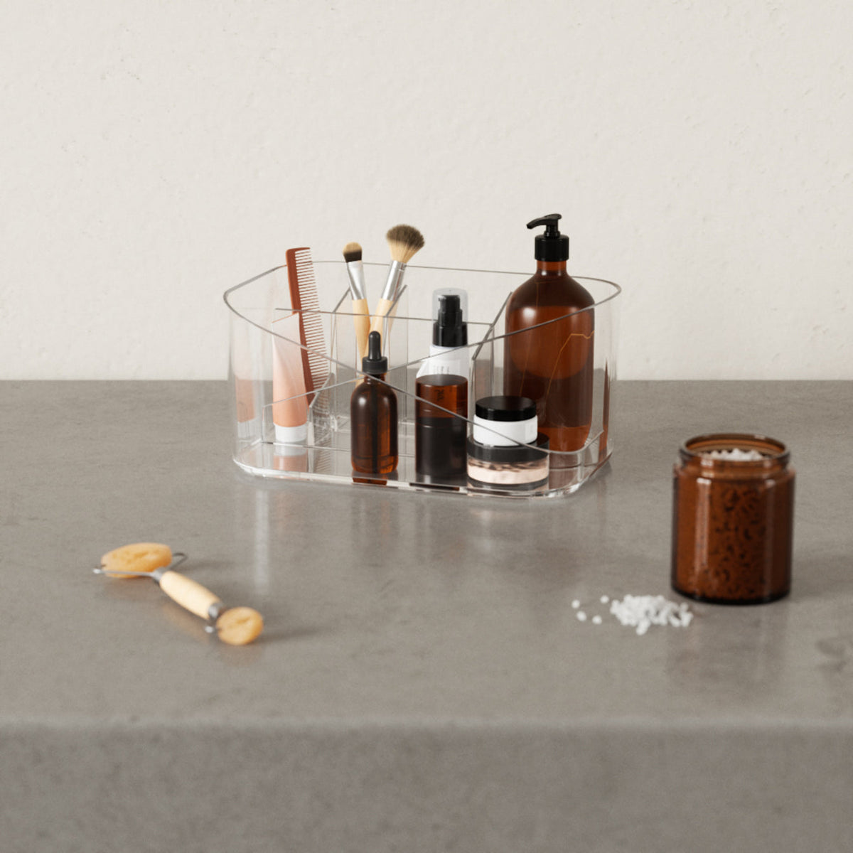 An Umbra GLAM Cosmetic Organizer adorned with various cosmetics and brushes, perfectly arranged in a glass container.
