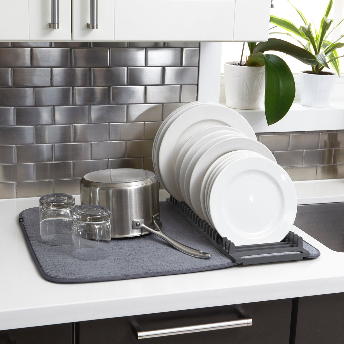 Umbra Udry dish rack and grey drying mat on a benchtop with plates and glasses