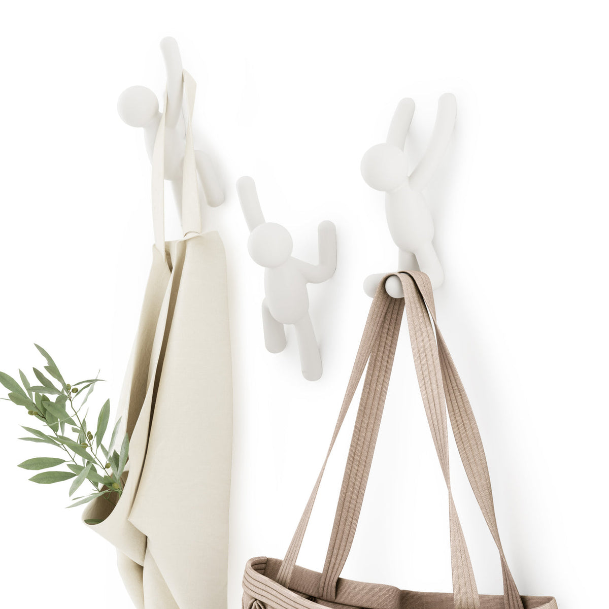 Umbra Buddy hooks in white holding a cream coat and a canvas tote by its straps