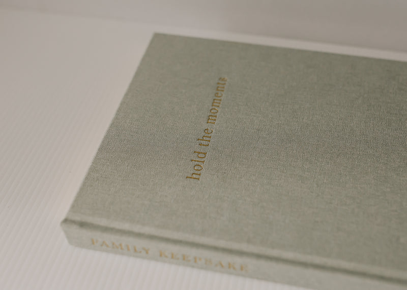 A Olive + Page - Hold The Moments Journal with the words build the memories on it.