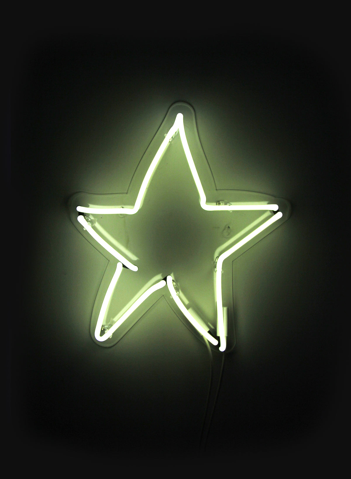 Star wall neon glowing pale green-yellow against a dark wall