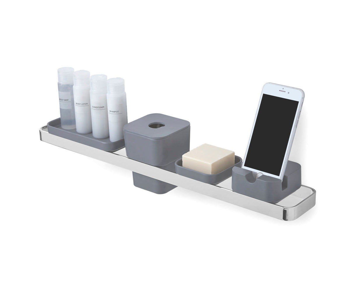 Wall shelf holding the SCILLAE canister, toiletry bottles, soap and a phone, on white