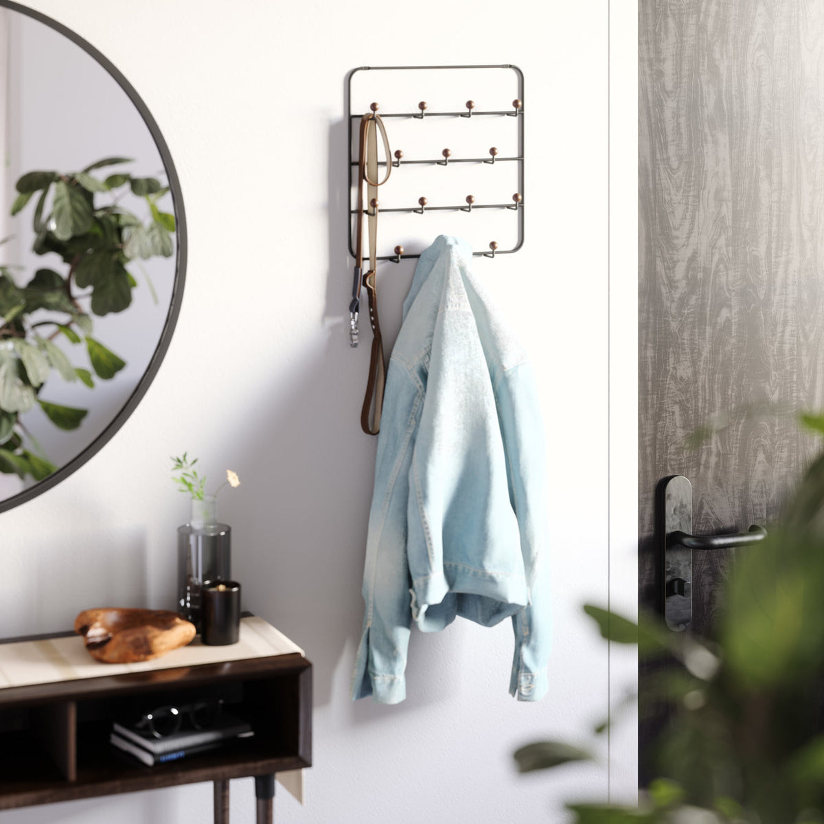 Umbra Estique over the door organizer mounted with bags and umbrellas hanging