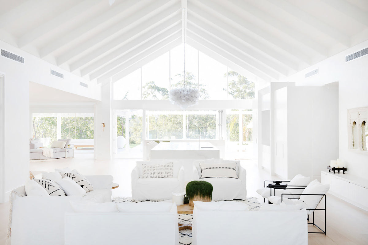 Vaulted white living room with sofas and garden views
