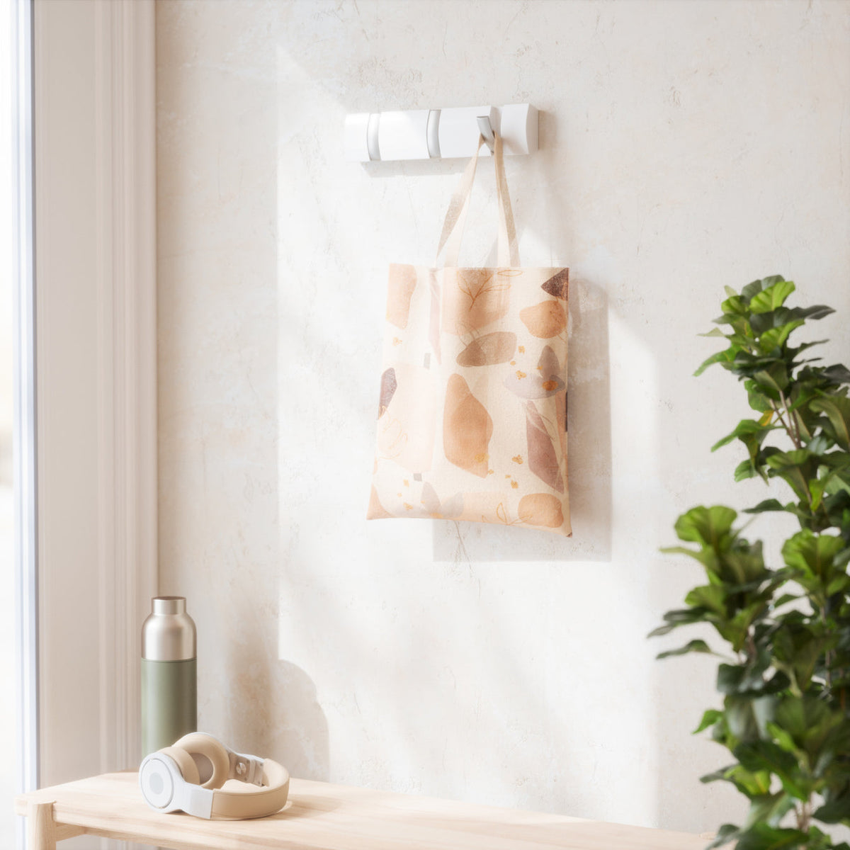 Umbra Flip 3 hook rack in white holding a printed tote beside a plant