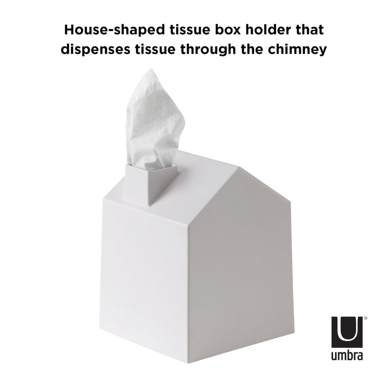 Umbra's Casa Tissue Box Cover White, a Scandinavian-inspired decor item in the form of a house-shaped tissue box, dissipates tissue through the chimney.