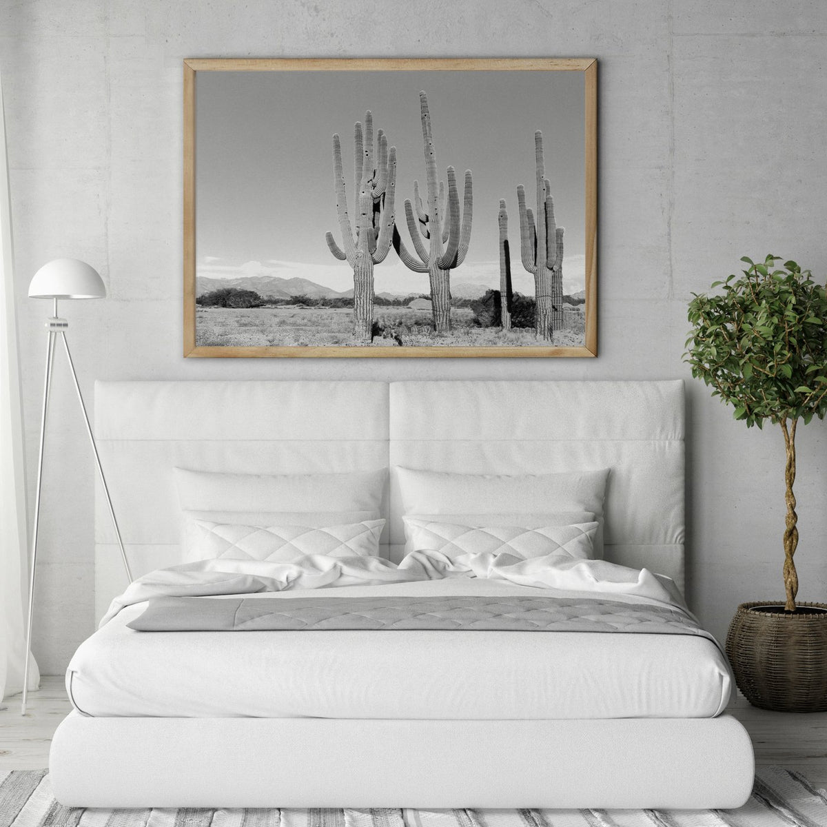 Cactus print in a timber frame above a white upholstered bed