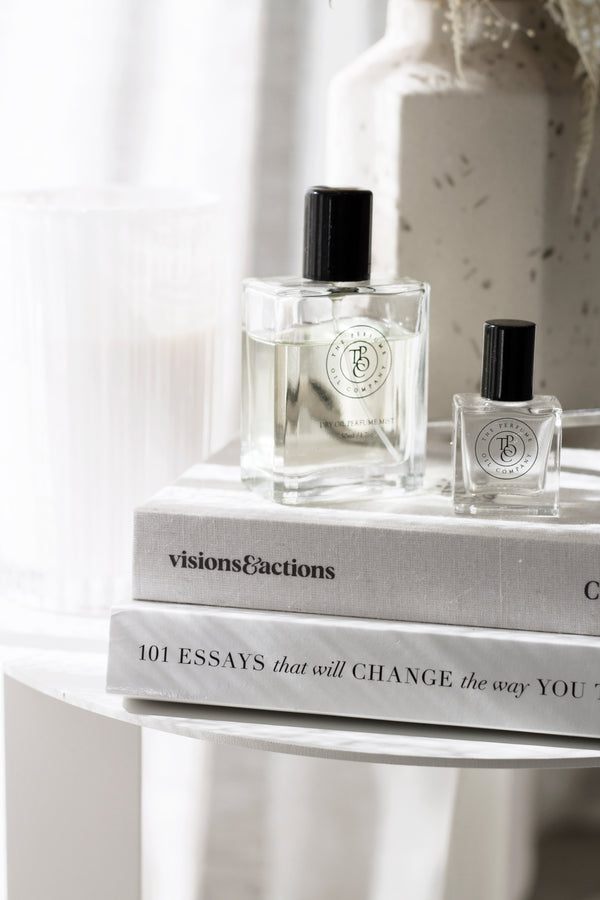 Close-up of Brianna Wiest’s book 101 Essays That Will Change The Way You Think styled with perfume bottles and neutral decor.