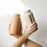 A pair of hands holding a Bink Day Bottle with Hydration Tracker - Various Options.