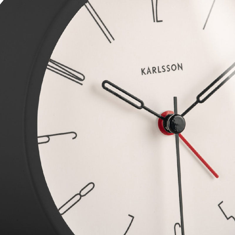 Close-up of the Black Belle alarm clock's white dial and red second hand