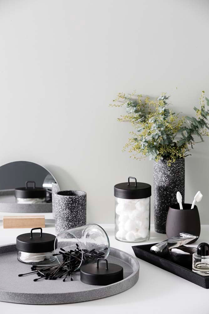 A Zakkia Terrazzo Vessel - Black utilized for storage, showcasing a collection of black and grey items arranged neatly on a tray.