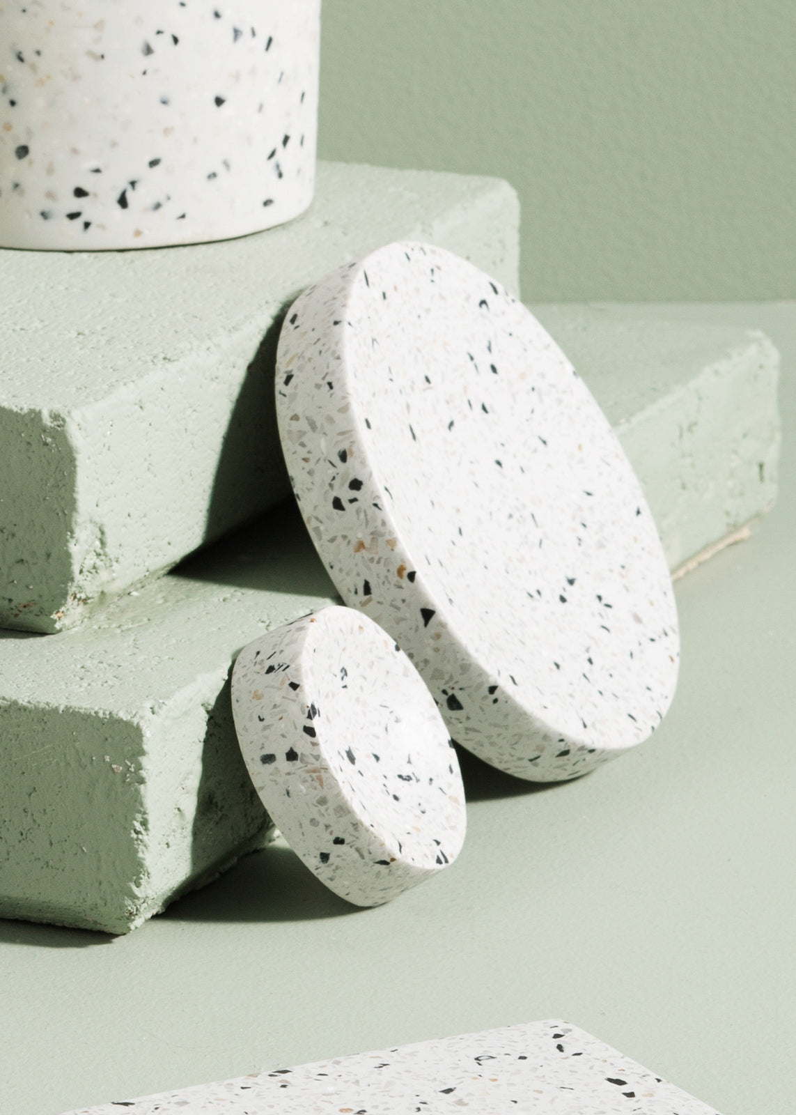 A set of medium-sized Zakkia Terrazzo Dimple Tray - Medium Snow jars on a Terrazzo tray.