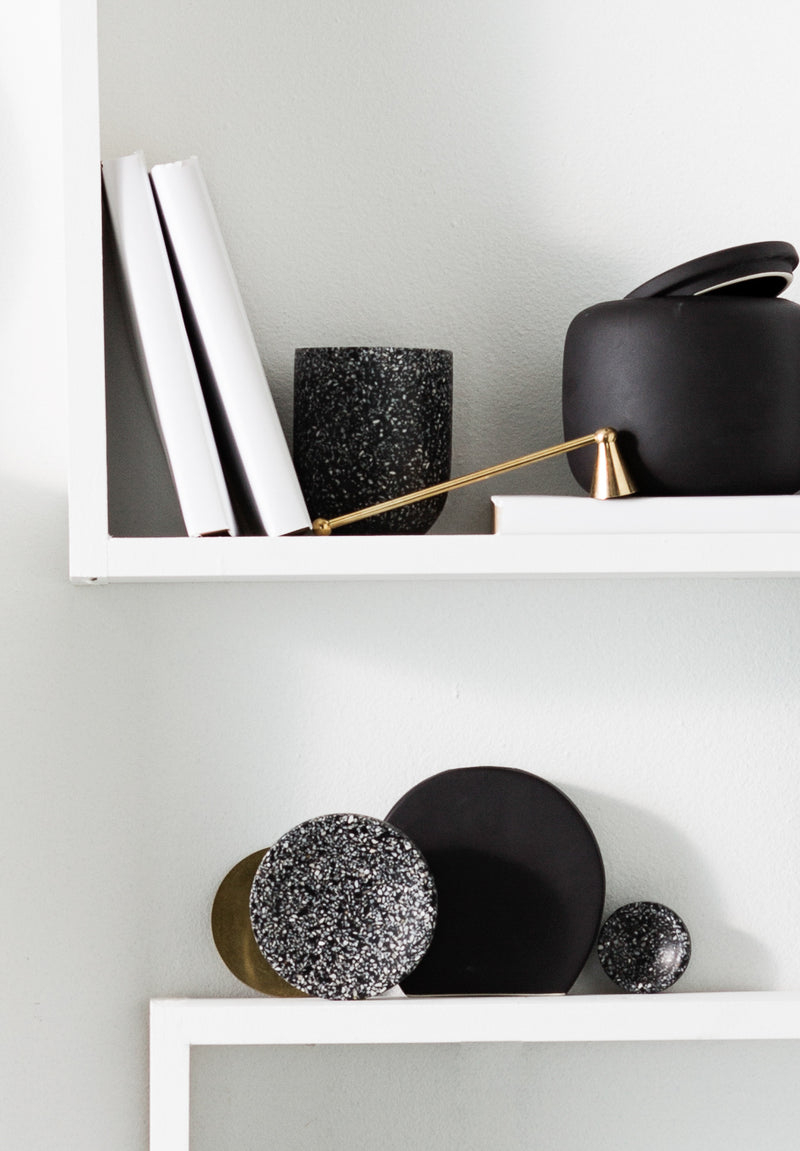 A white shelf adorned with a Terrazzo Dimple Tray - Small Black and black and gold Zakkia items.