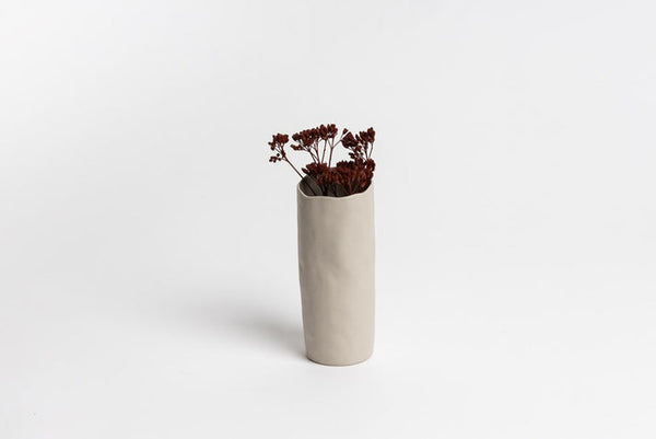 A small Bernie Vase - Small Bone with dried florals on a white surface, by Ned Collections.