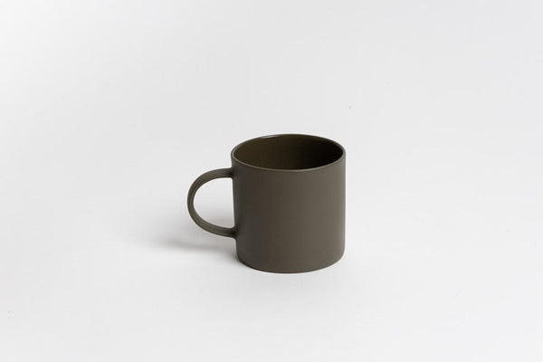 A small olive green Ned Collections Jon Boy Mug in stoneware, placed on a white surface.
