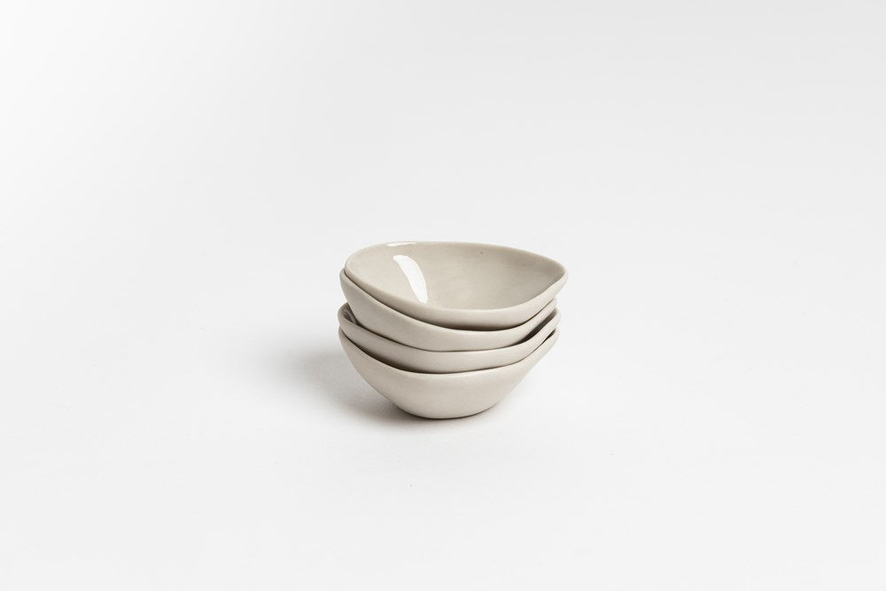 Stack of bone Haan mini dishes, on pale grey
