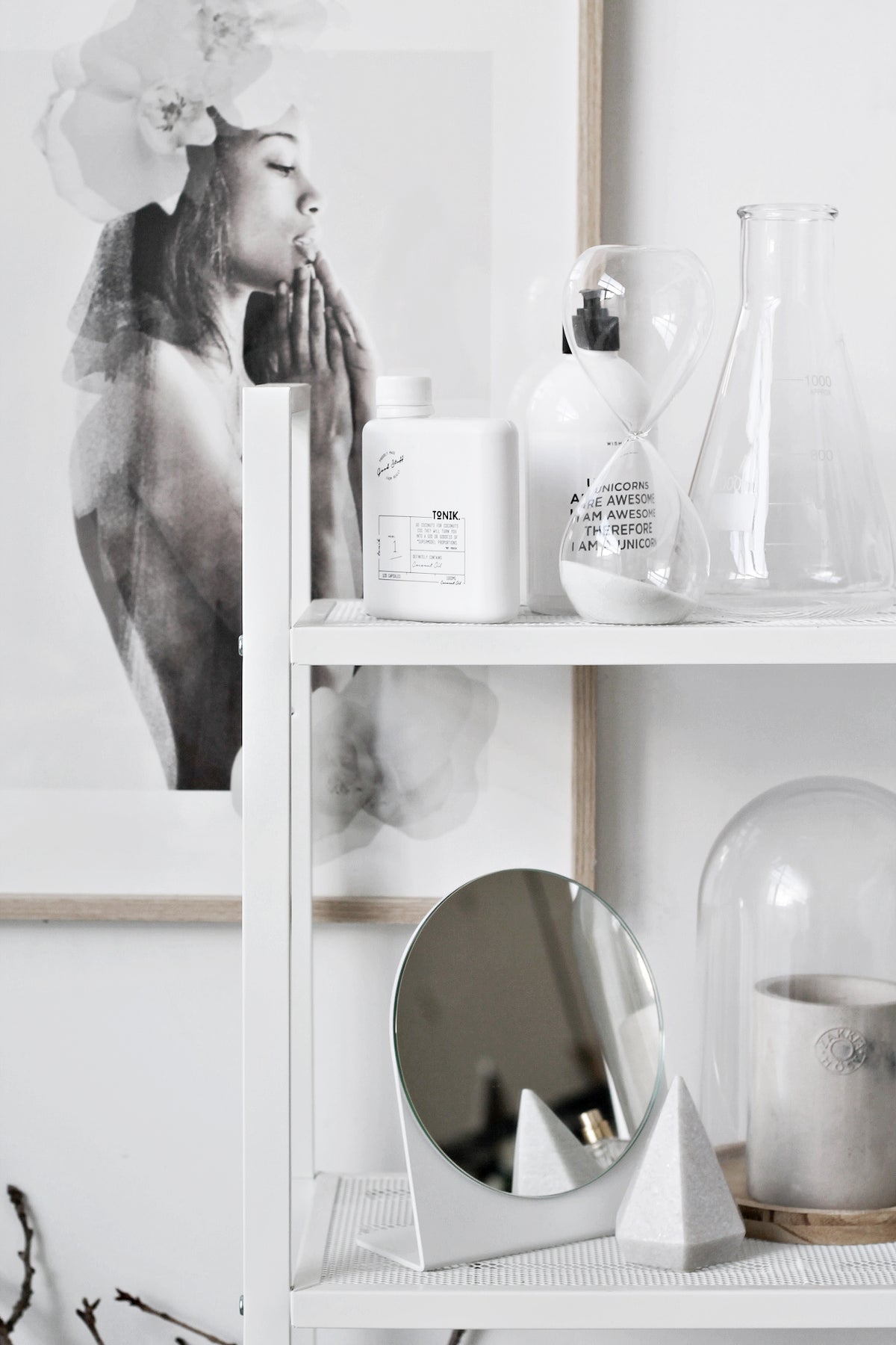 Wider view of the ladder shelf, the hourglass sitting between bottles and a glass flask