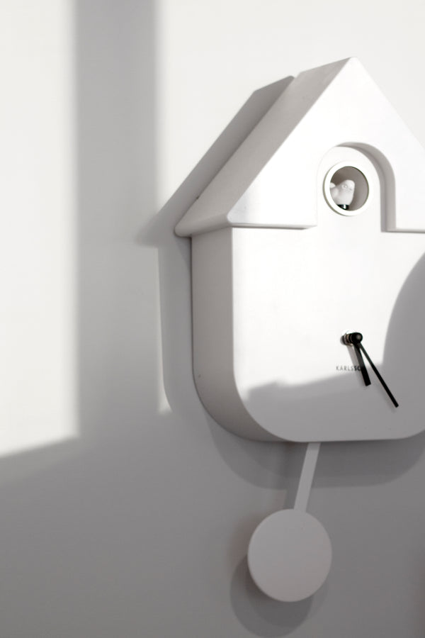 An open face clock with a bird in the shape of a house, accompanied by bird song - The Karlsson Modern Cuckoo - Various Colours.