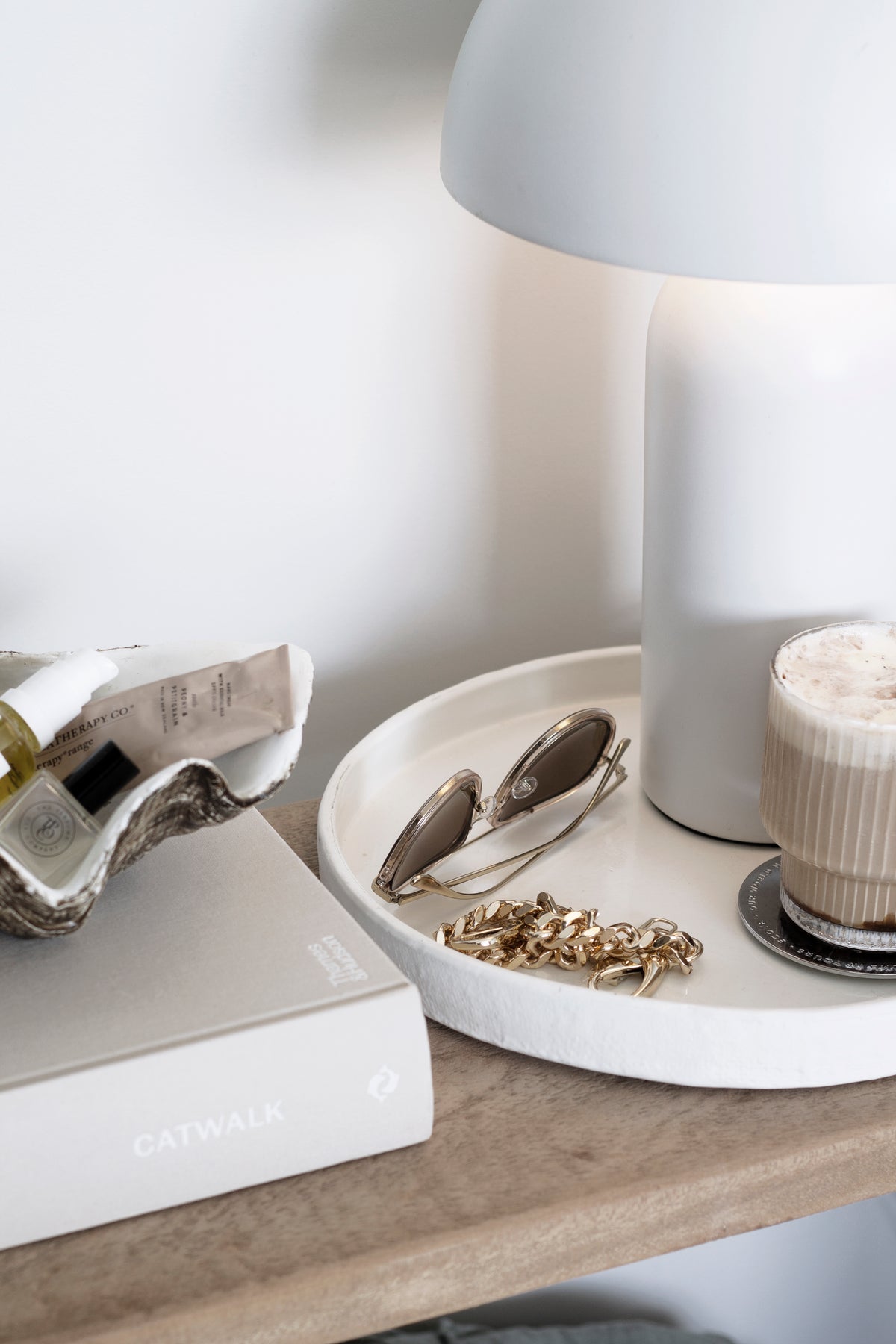 Close view of the burlap tray with a silver dish of gold jewellery and a coffee