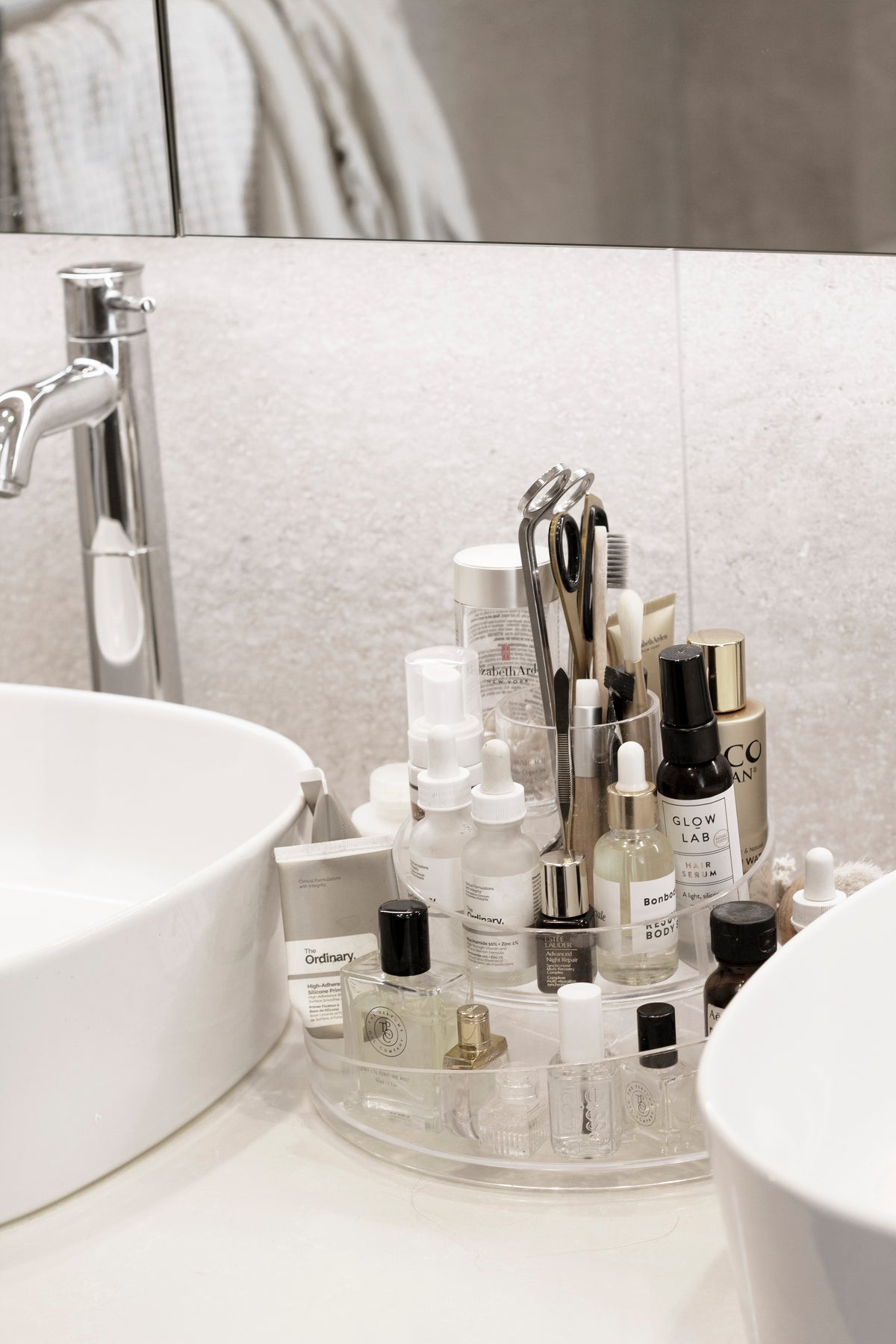 Umbra Cascada rotating cosmetic organiser on a vanity holding skincare bottles