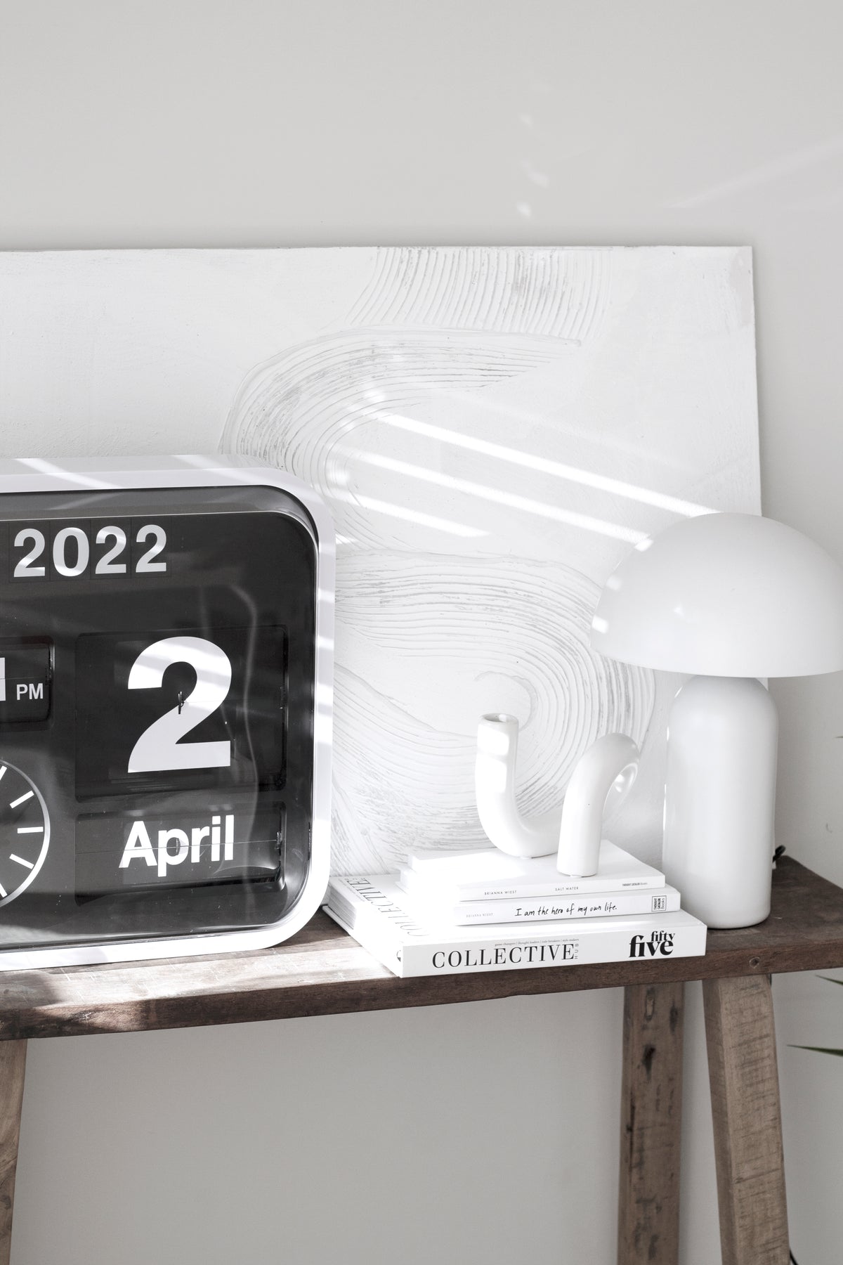 Collective Issue 55 on a side table beside a flip clock and a white mushroom lamp