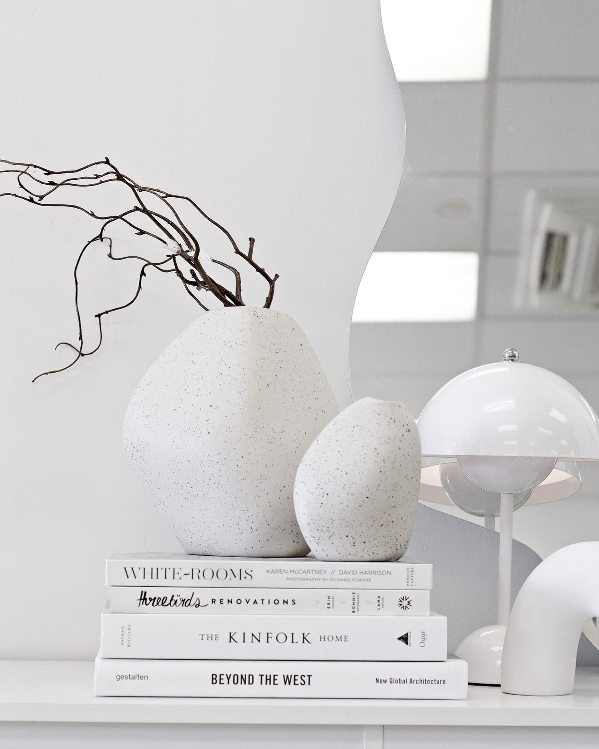Three Birds Renovations 400+ Renovation and Styling Secrets Revealed book styled on a shelf beside neutral home decor