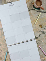 2026 Busy Big Box wall planner monthly calendar laid flat with pens and coffee on marble desk