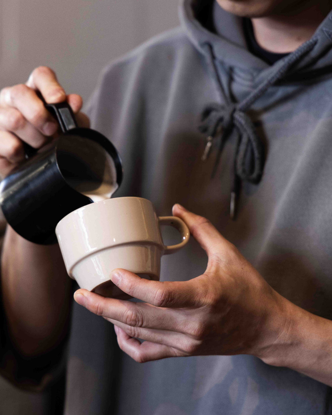 Barista pouring steamed milk into a Hudson Mug