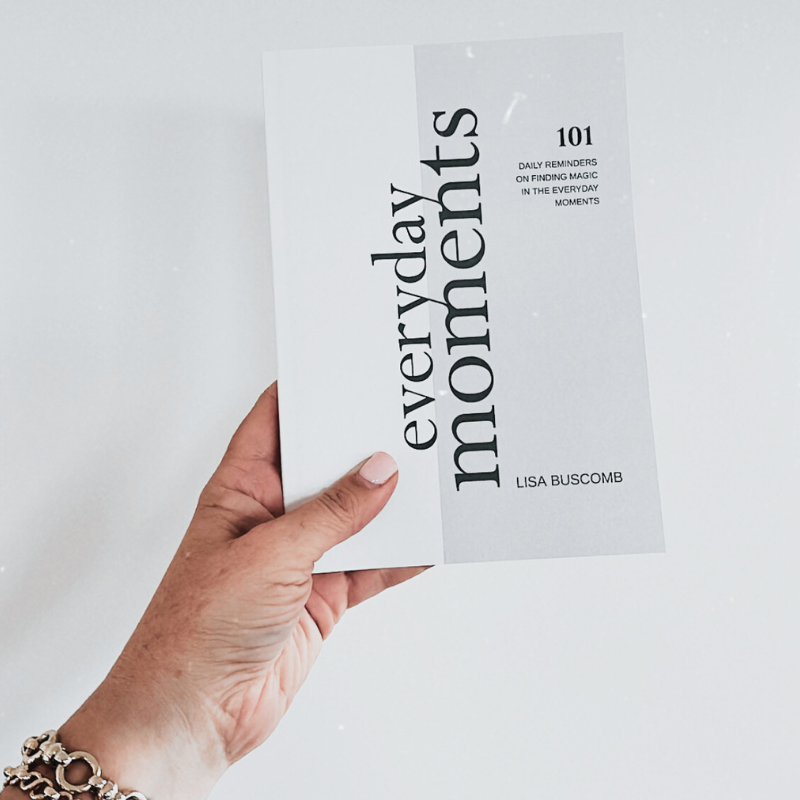 A woman lovingly holds up a Lisa Buscomb EVERYDAY MOMENTS Book.