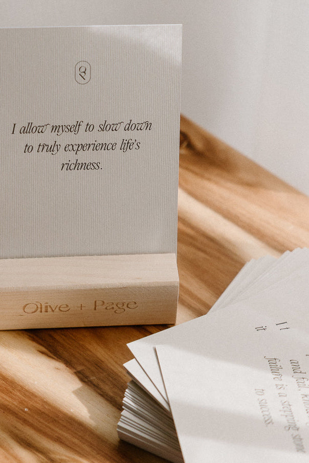 Affirmation card on a timber table beside a book