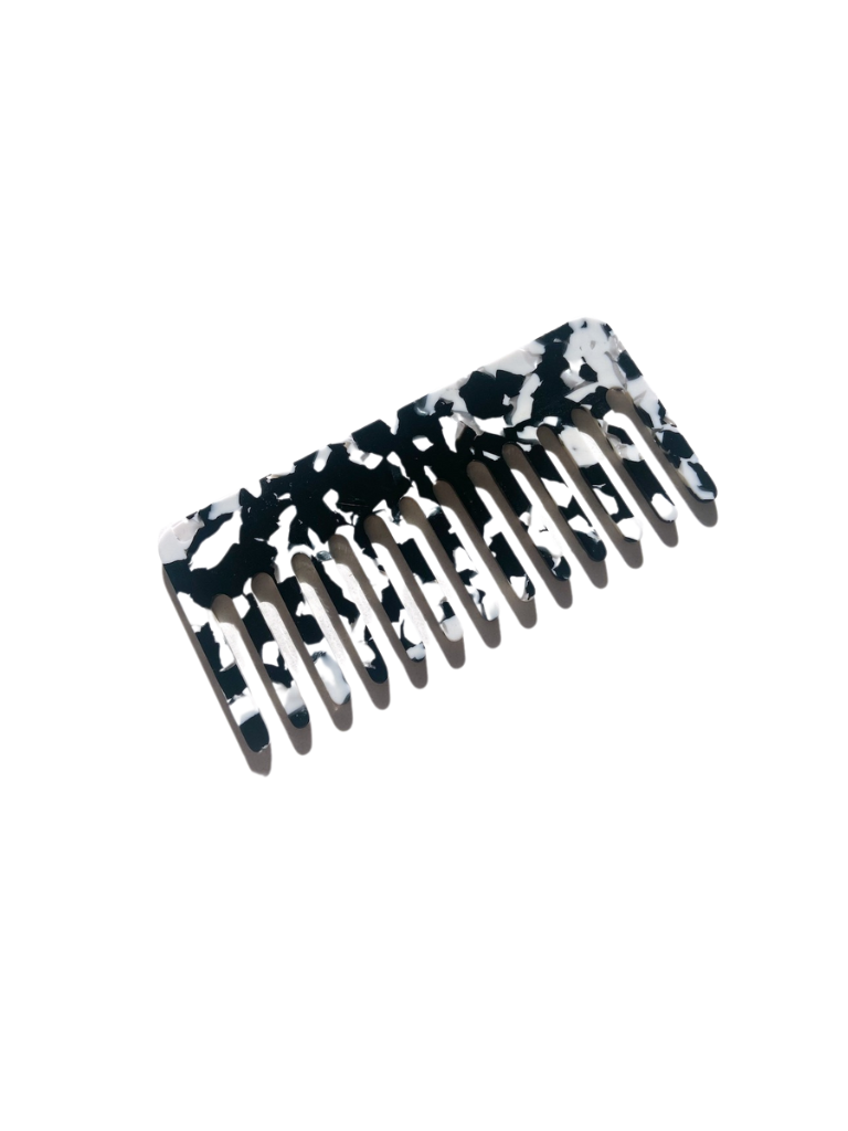 Black and white acetate comb angled on a plain white background