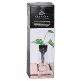 An Esschert Design self-watering bottle planter with a plant in it in front of a box.