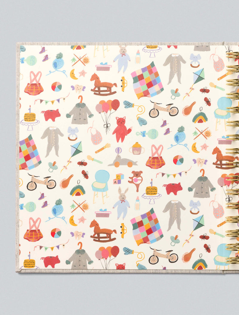 Colorful patterned baby journal notebook cover with various illustrations on a light gray background