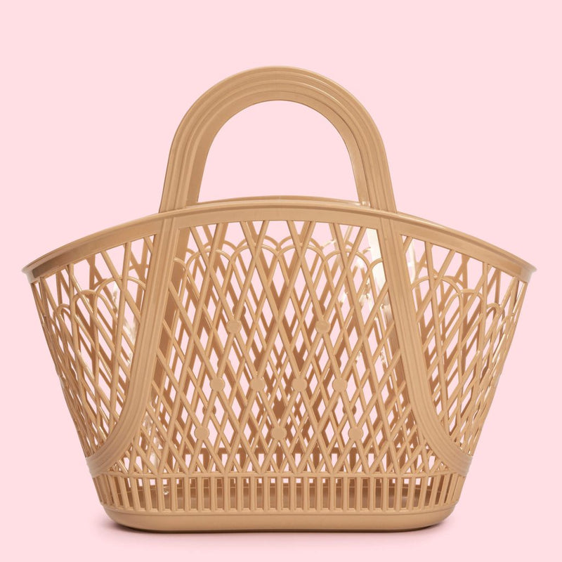 The Sun Jellies Betty Basket, a feminine design, is a beige woven basket presented on a vibrant pink background.