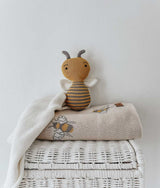 A Bengali Collections Honeybee Blanket sits on top of a wicker basket.