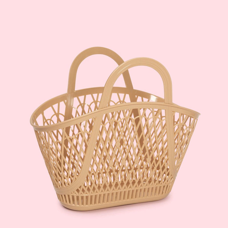 The Sun Jellies Betty Basket is a feminine design, crafted in a recyclable material, showcased against a pink background.