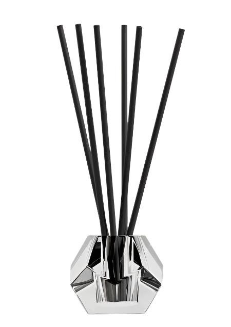 Blend aroma stick holder in faceted clear glass holding black aroma sticks, on white