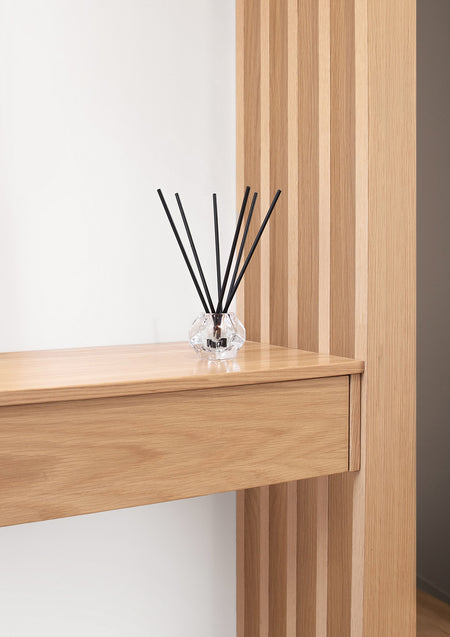 Aroma sticks on a timber console against a slatted timber wall