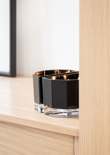 Blend candle pair on an oak side table next to a sheer curtain