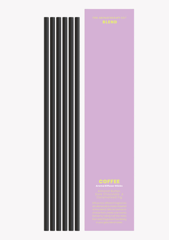 Coffee aroma sticks with the black reeds laid beside the lilac Blend sleeve