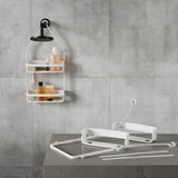 A white bathroom with a shower shelf displaying essentials from the Umbra FLEX SHOWER CADDY - Black / White range.