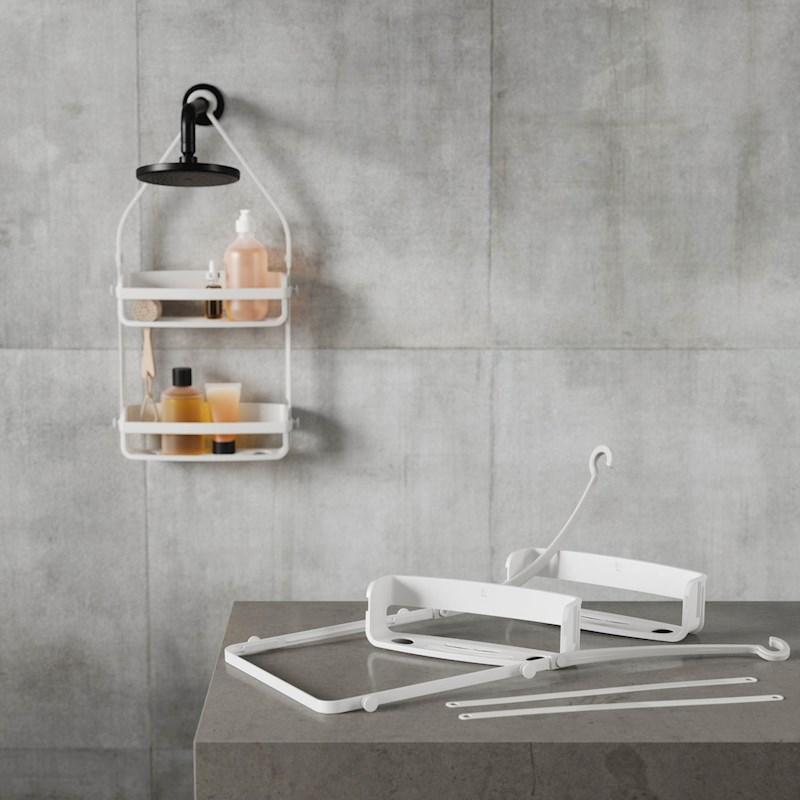 A white bathroom with a shower shelf displaying essentials from the Umbra FLEX SHOWER CADDY - Black / White range.