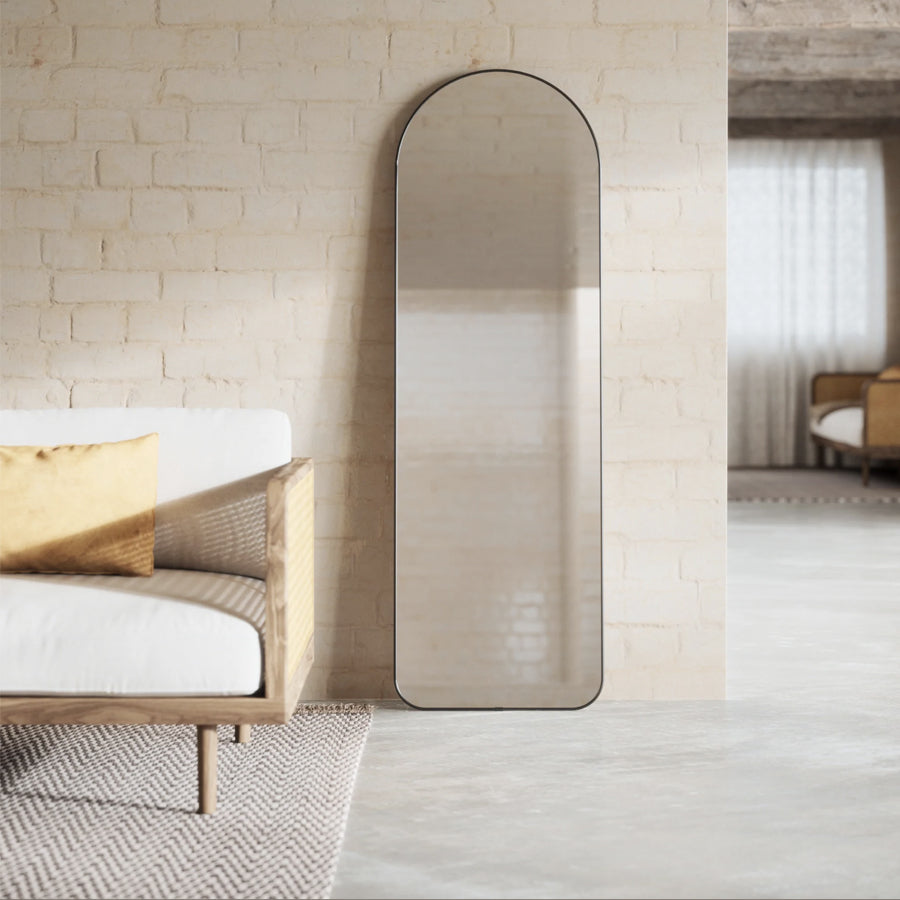 Umbra Hubba arched leaning mirror styled in an entryway beside a console