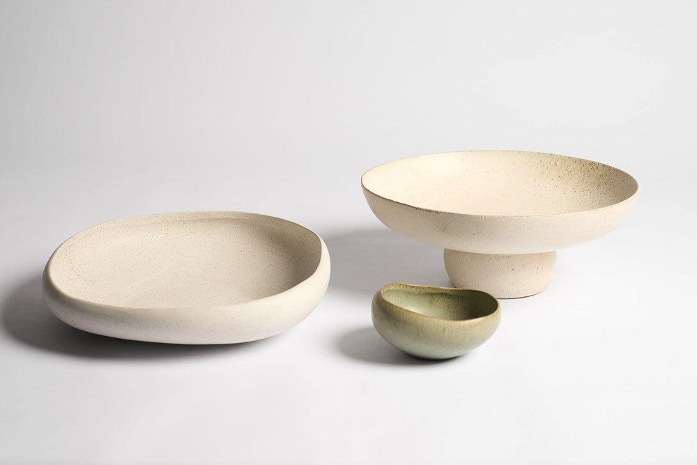 Three ceramic bowls of different sizes on a light gray background