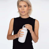 A woman in a black top holding a Bink Day Bottle with Hydration Tracker - Various Options for hydration tracking.