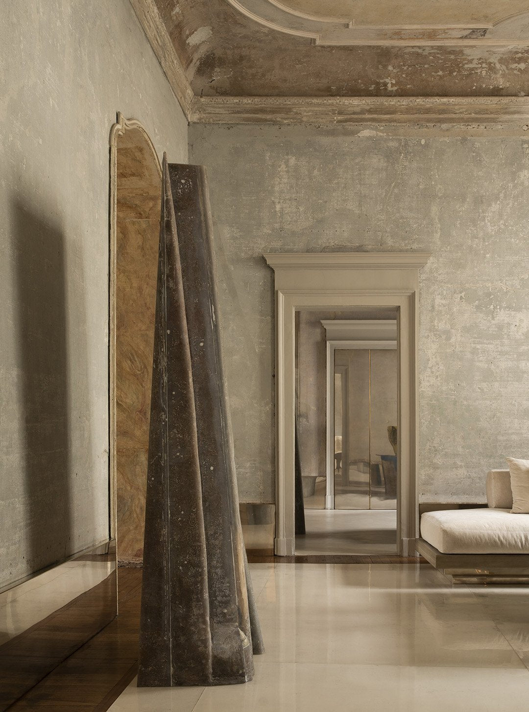 Interior featured in the book: a stone-walled room with an arched doorway and draped textiles