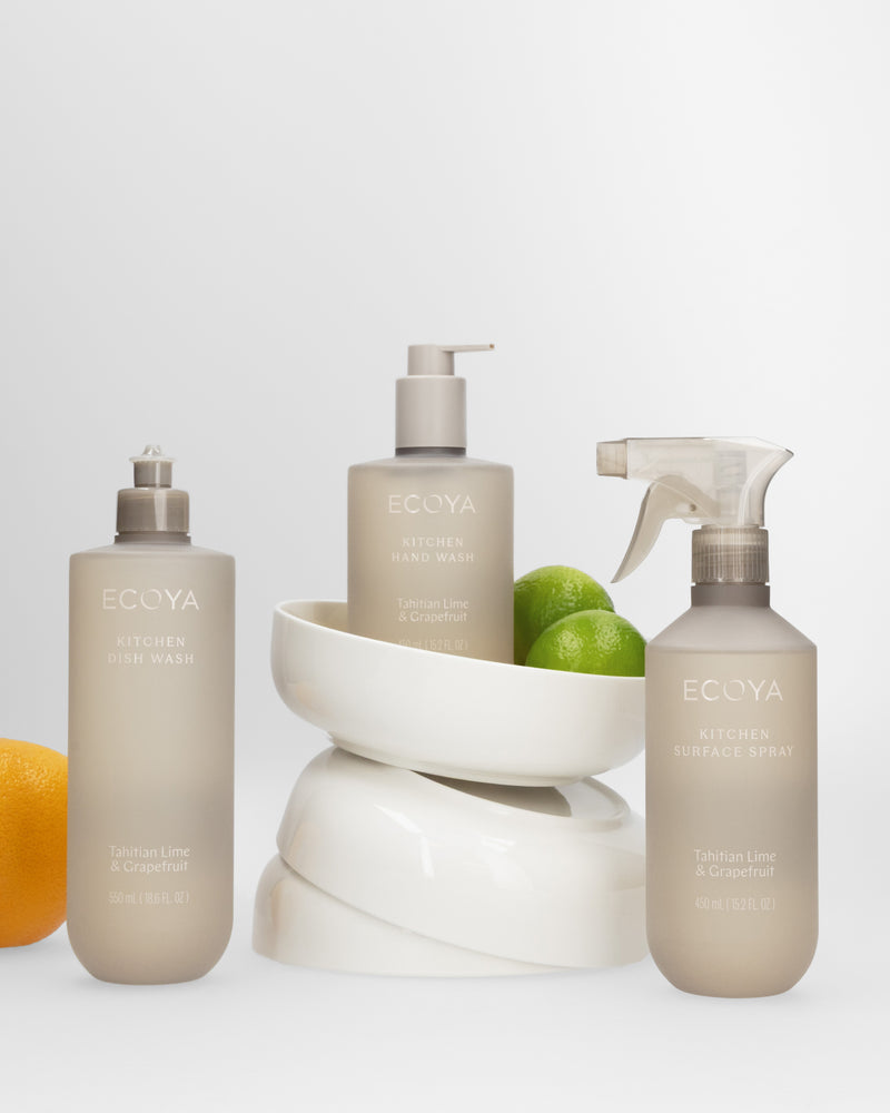 Ecoya Tahitian Lime & Grapefruit hand wash, dish wash and surface spray styled with white ceramic bowls, a lime and a lemon