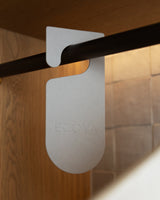 Ecoya closet tag hanging on a wardrobe rail among clothing