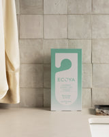 Ecoya closet tag styled in a linen cupboard with folded sheets