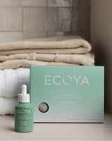Ecoya wool dryer ball set styled in a laundry with folded towels